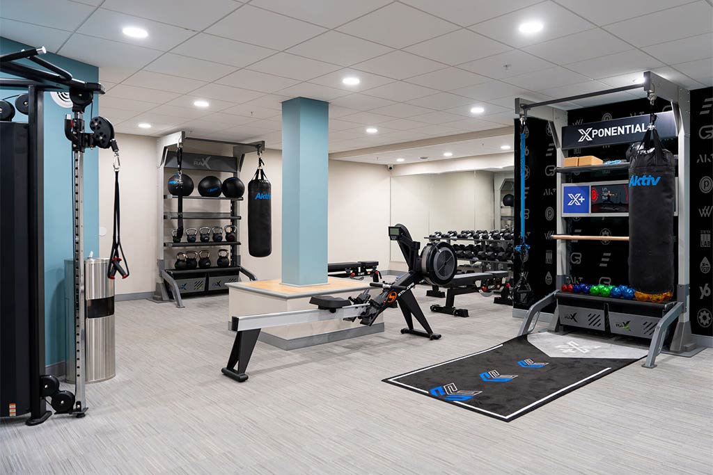 xplus-functional-training-equipment-hotel-gym Double Xponential+ Training Bays with digital exercise guidance on the wall and gym flooring.